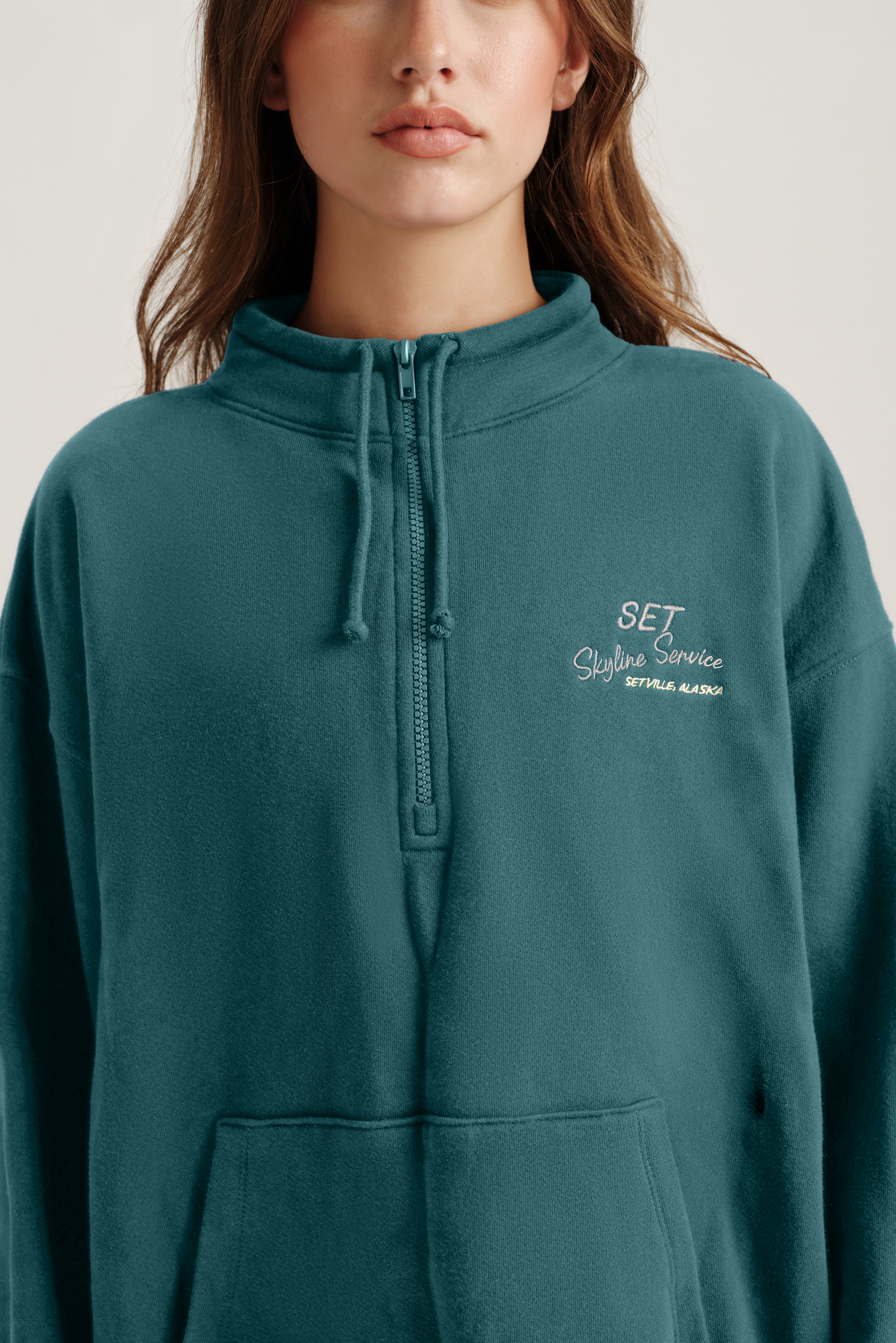 Teal hoodie with a brand logo on a plain background