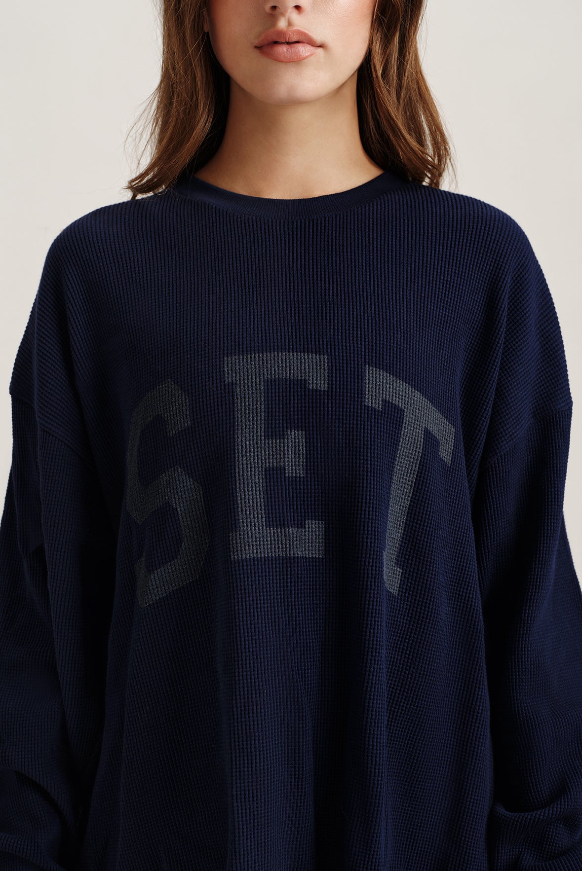 Close up of navy blue long sleeve with 'SET' text