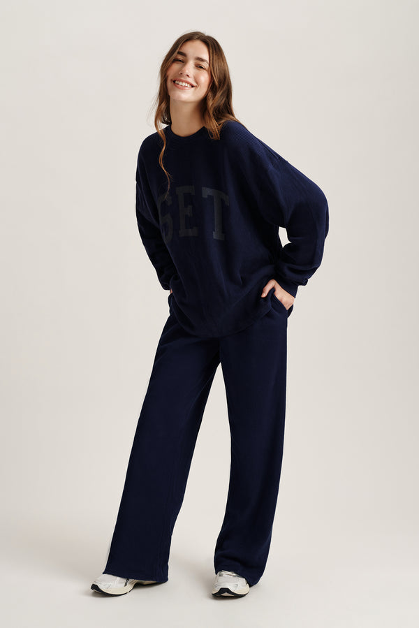 Person wearing a navy blue outfit with 'SET' text on a white background