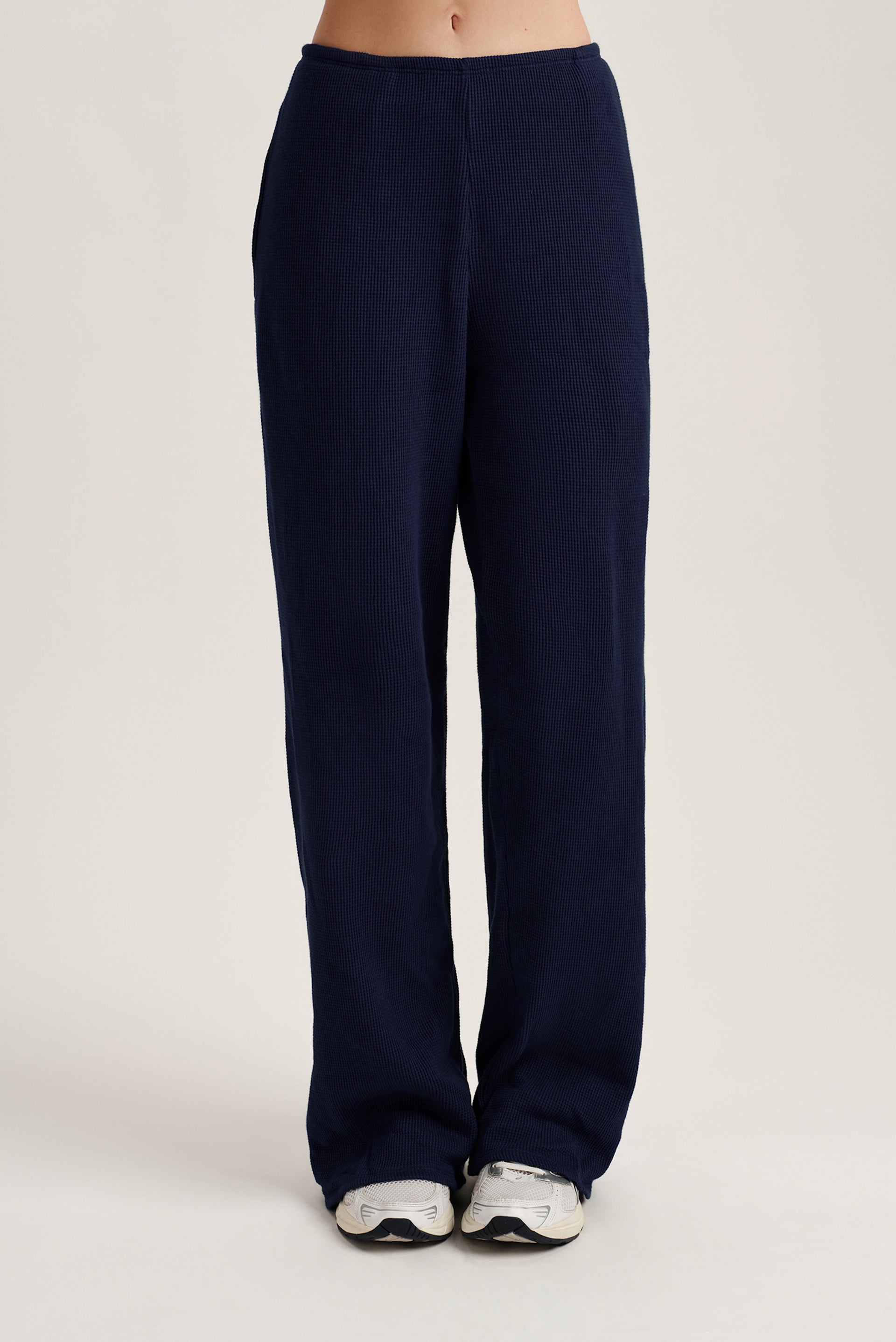 Navy blue pants on a white background <model-info>Kalia wears a size S and is 5’9, 23” waist, 32B bust.</model-info> 