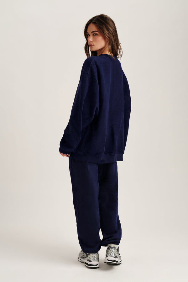 Person wearing a navy blue tracksuit on a white background