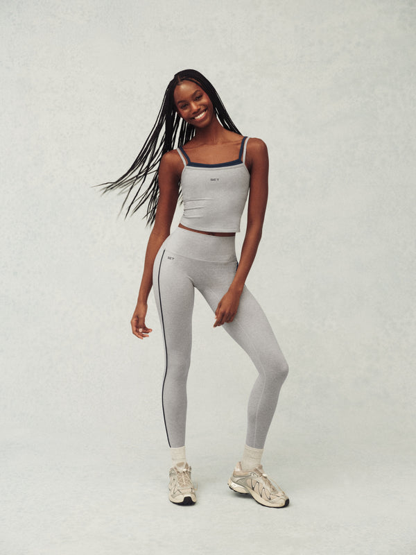 Woman wearing a gray athletic outfit on a white background