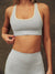 Person wearing a gray sports bra and leggings set against a neutral background