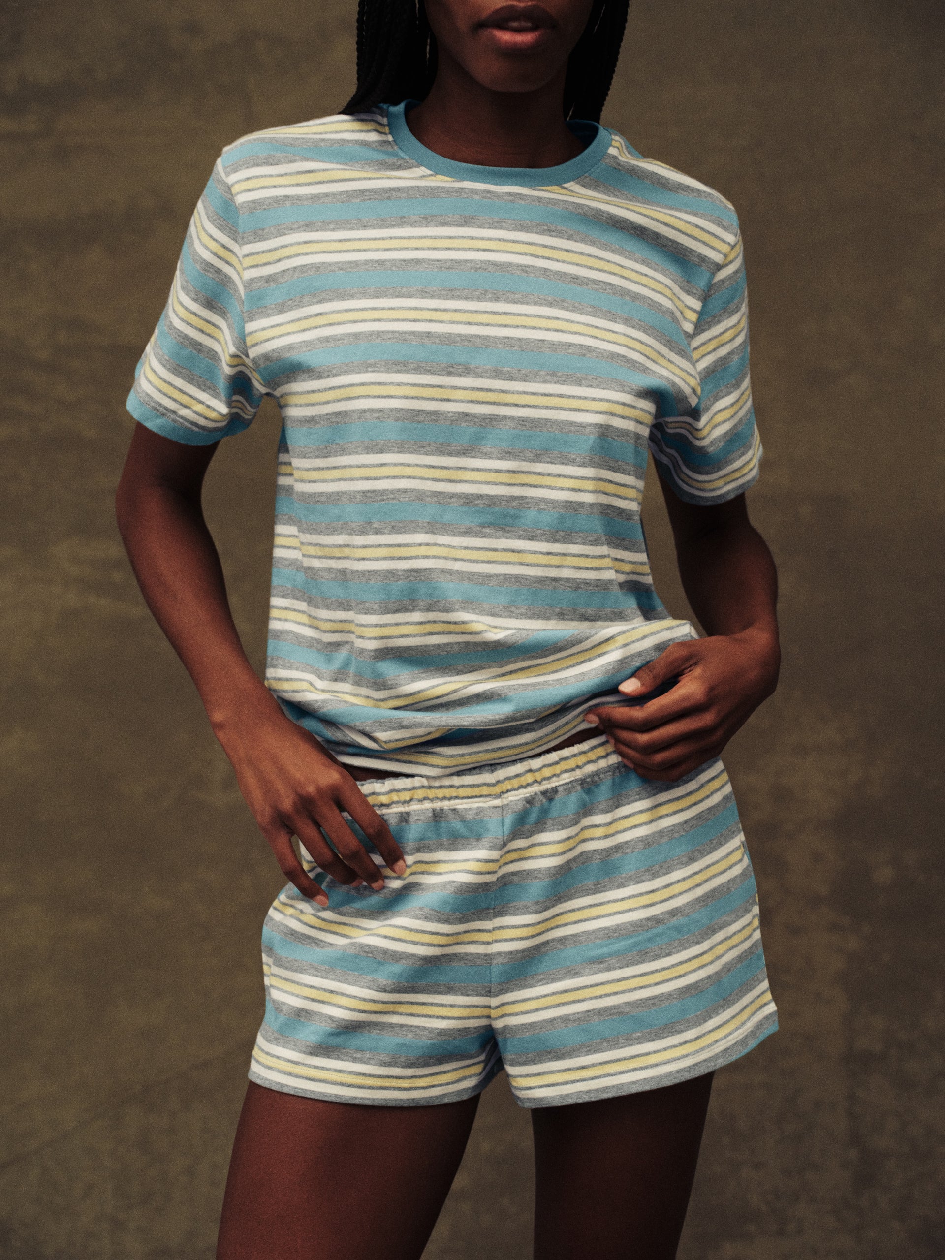 Person wearing a blue and white striped outfit against a brown background