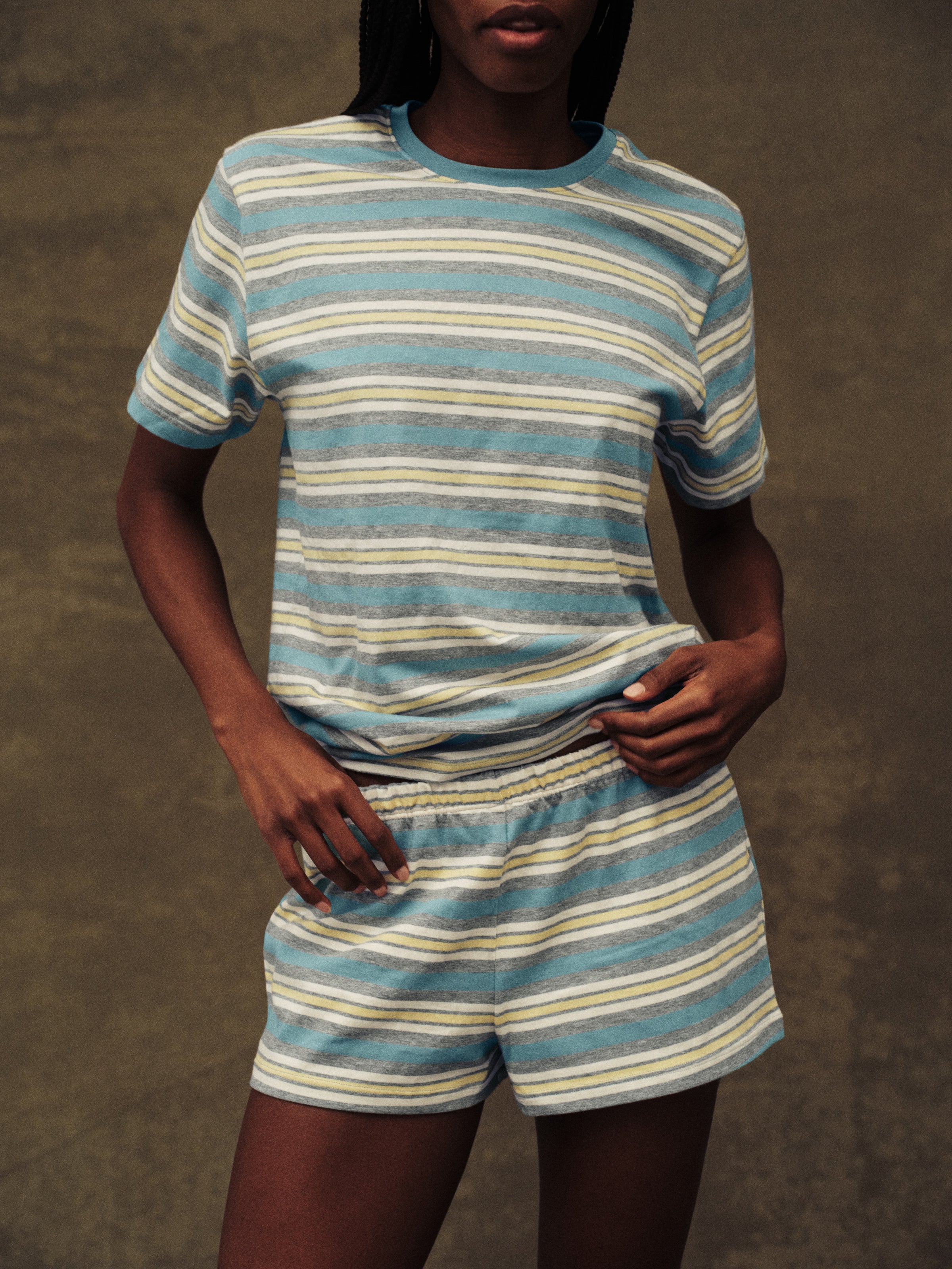 Person wearing a blue and white striped outfit against a brown background