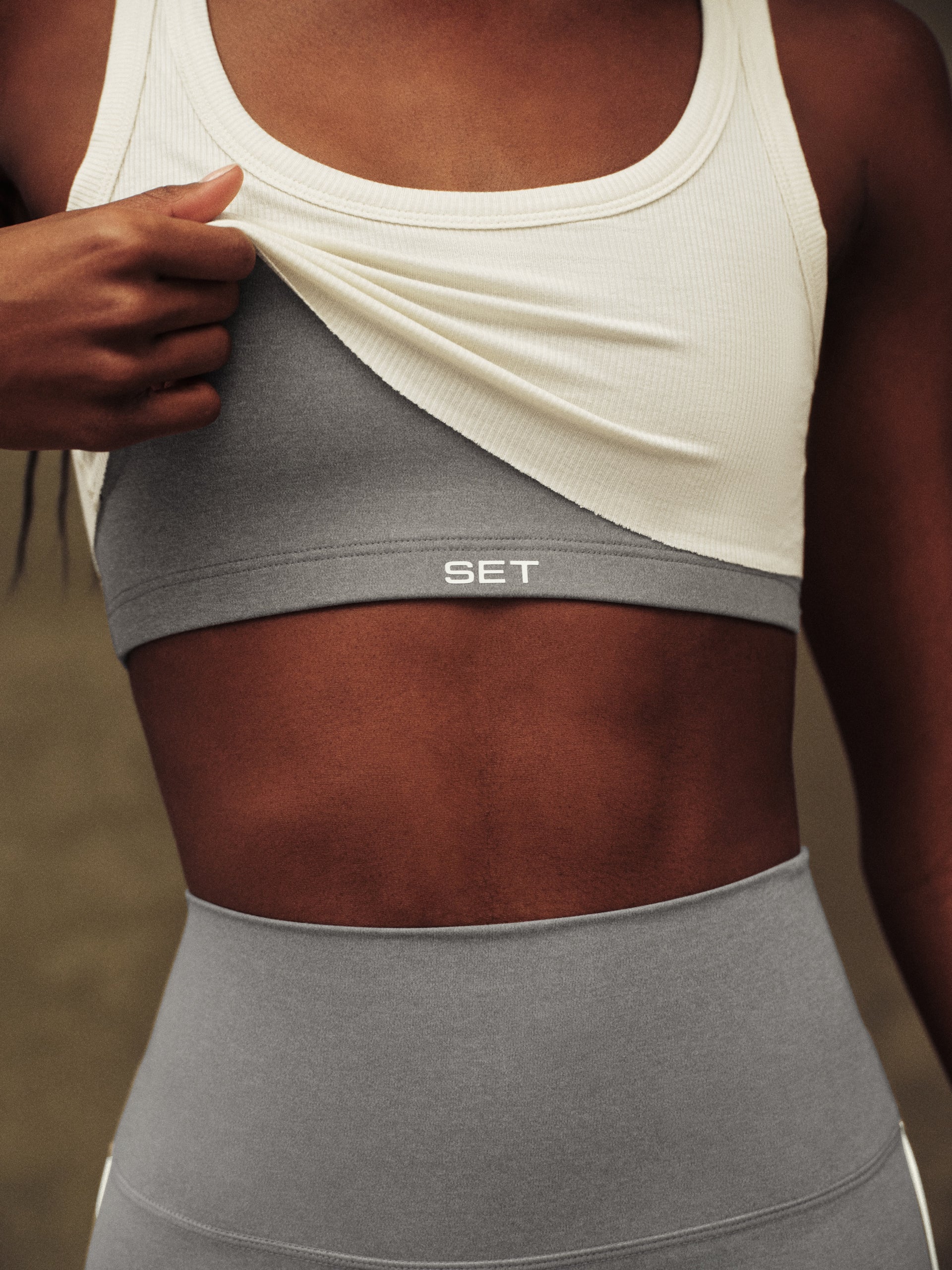 Gray and white sports bra with 'SET' branding on a blurred background
