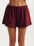 Maroon shorts worn by a person on a white background