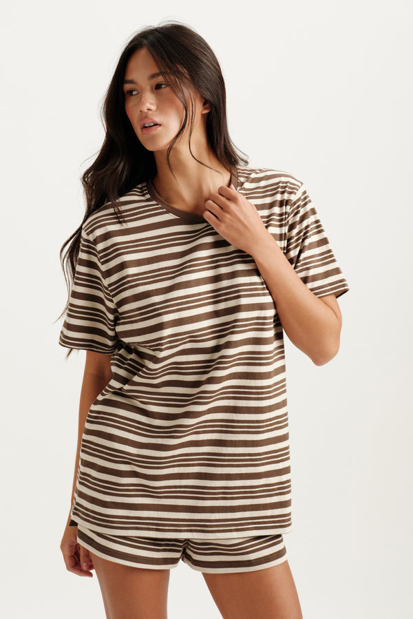 Woman wearing a striped shirt and shorts set on a white background 