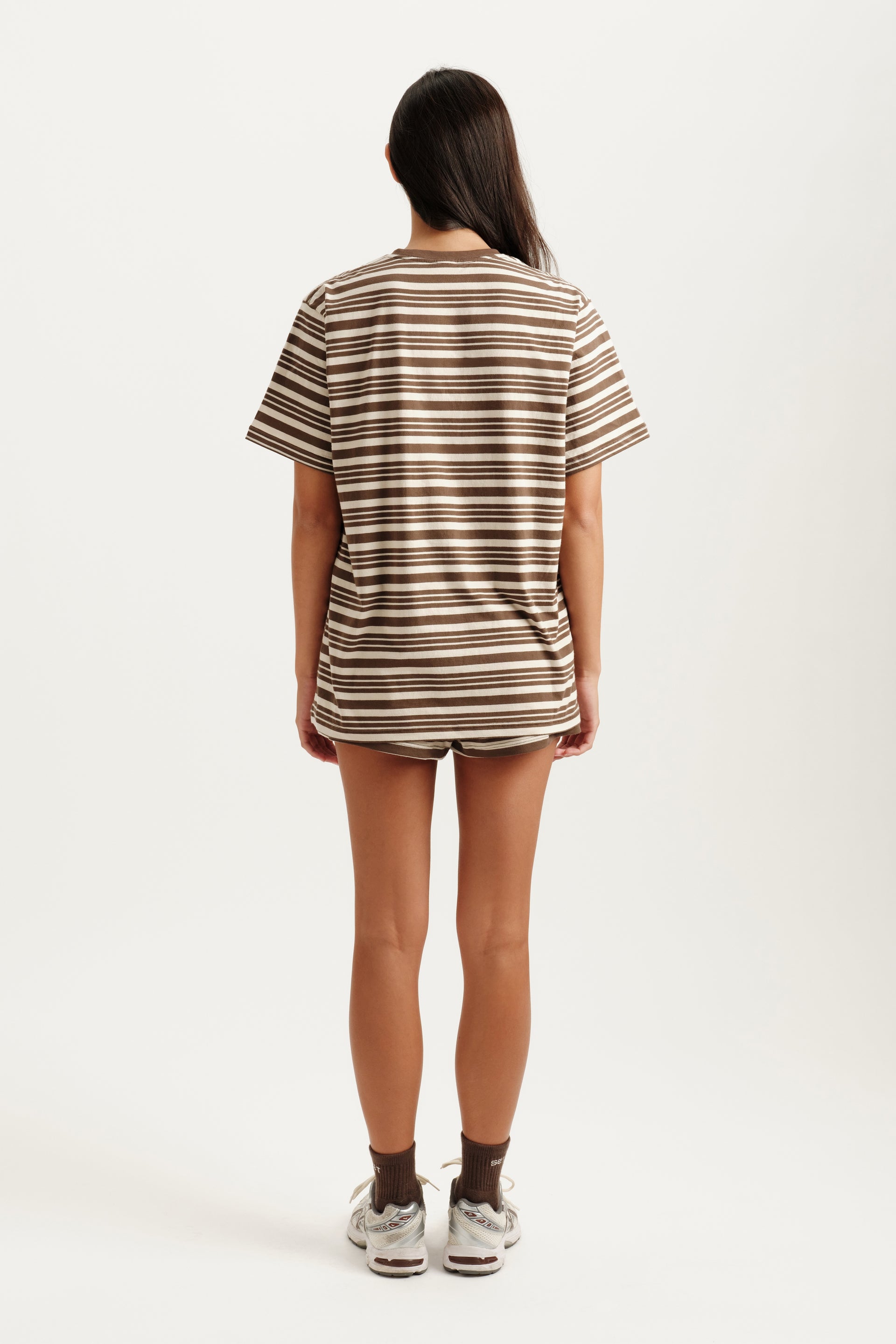 Person wearing a striped t-shirt and shorts on a white background