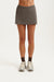 Person wearing a gray athletic skirt on a white background <model-info>Jelene wears a size XS and is 5’7”, 23” waist, 32AB bust.</model-info>