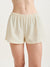 Beige shorts worn by a person on a white background