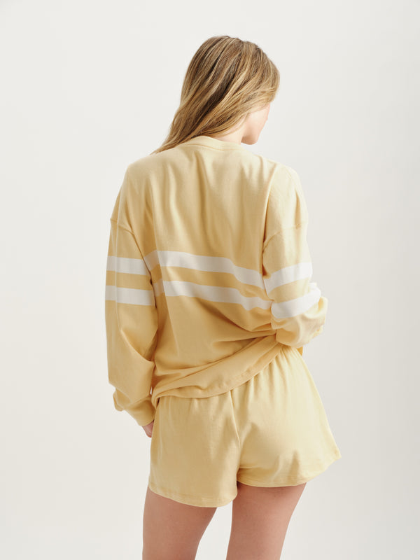 Person wearing a yellow outfit with white stripes on a plain background