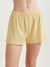 Yellow shorts worn by a person on a plain background