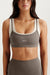 Woman wearing a gray sports bra with 'SET' branding on a white background