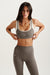 Woman wearing a gray sports bra and leggings with 'SET' branding on a white background <model-info>Jelene wears a size XS and is 5’7”, 23” waist, 32AB bust.</model-info>
