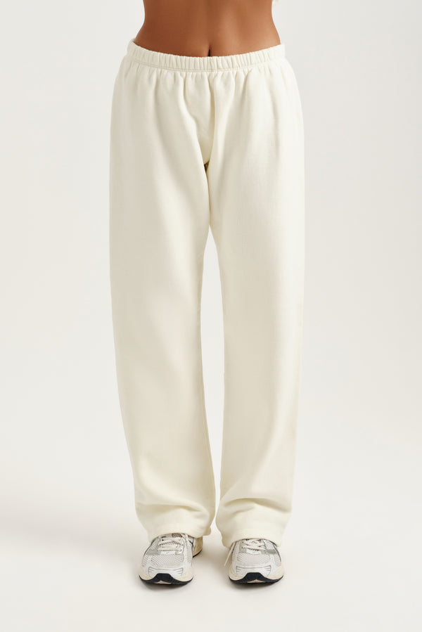 Cream sweatpants worn by a person on a white background
