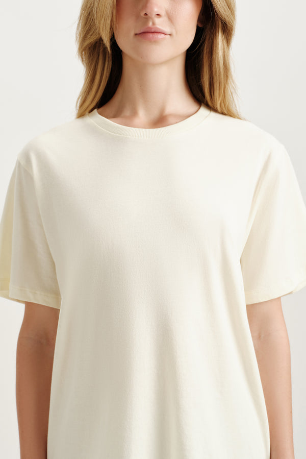 Woman wearing a light yellow t-shirt against a plain background