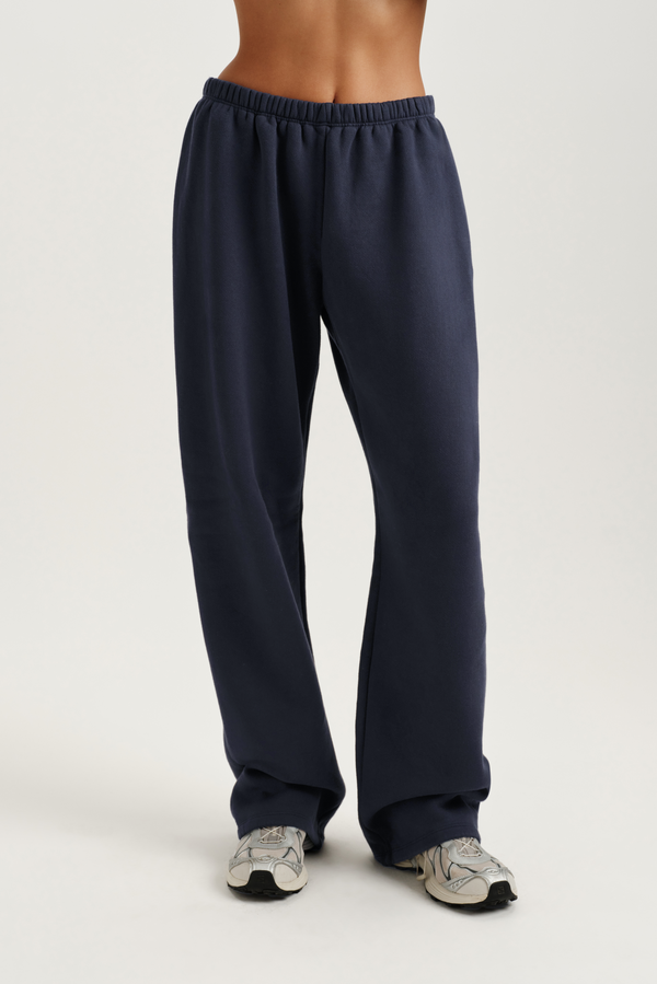 Navy blue sweatpants worn by a person on a white background 