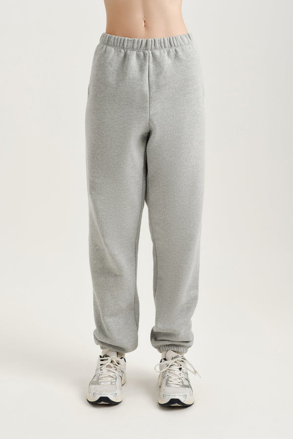Gray sweatpants worn by a person on a white background