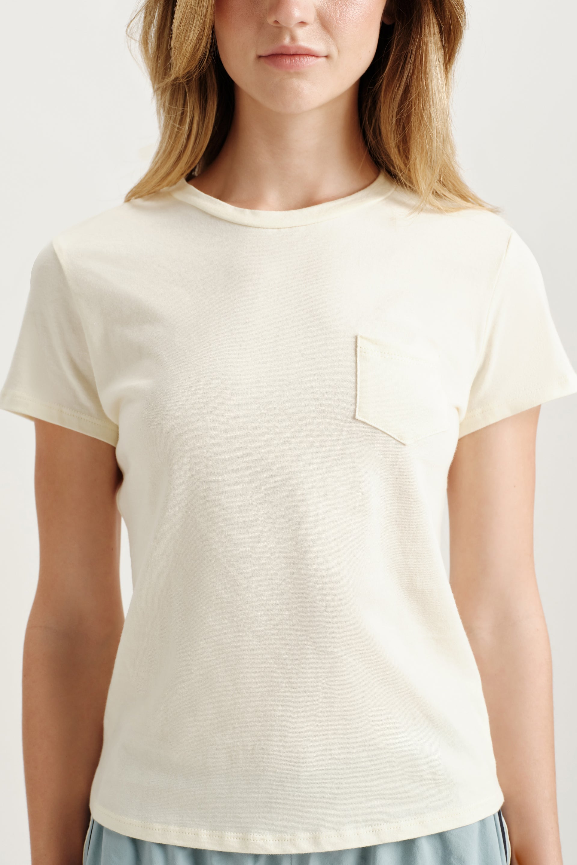 Person wearing a plain white t-shirt on a light background