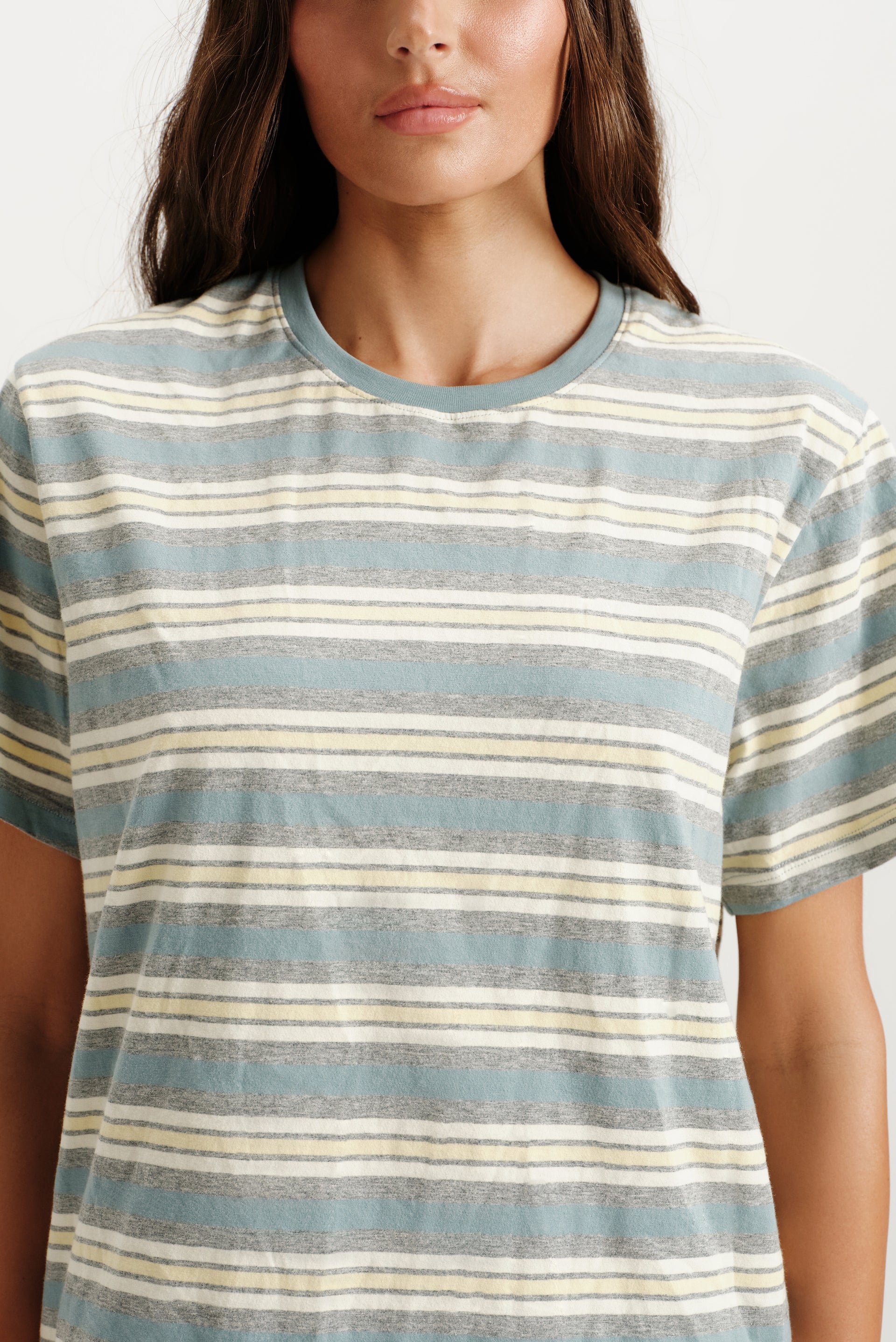 Woman wearing a striped t-shirt with blue and beige horizontal stripes.