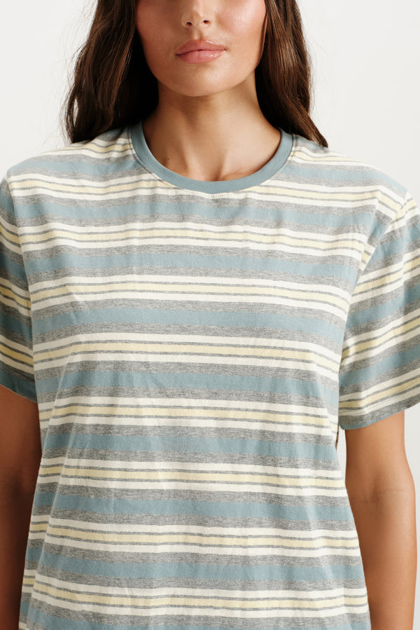 Woman wearing a striped t-shirt with blue and beige horizontal stripes.