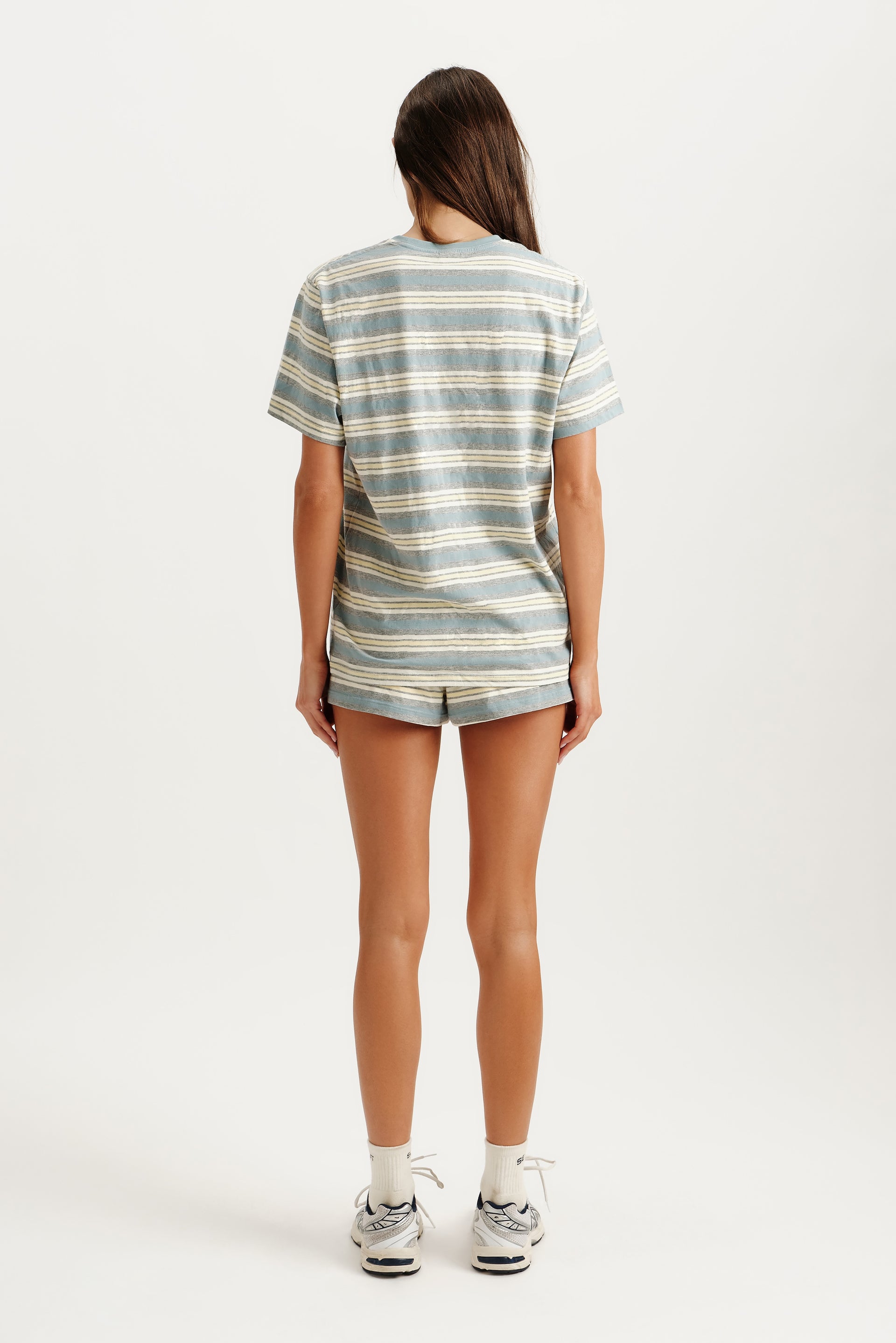 Person wearing a striped shirt and shorts on a white background