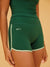 Green athletic shorts with 'SET' branding on a beige background <model-info>Meeya wears a size XS and is 5’7, 23” waist, 32B bust.</model-info> 