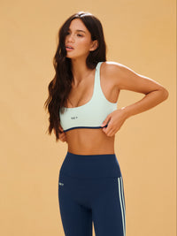 Woman wearing a sports bra and leggings on a beige background 