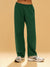 Green sweatpants worn by a person on a beige background