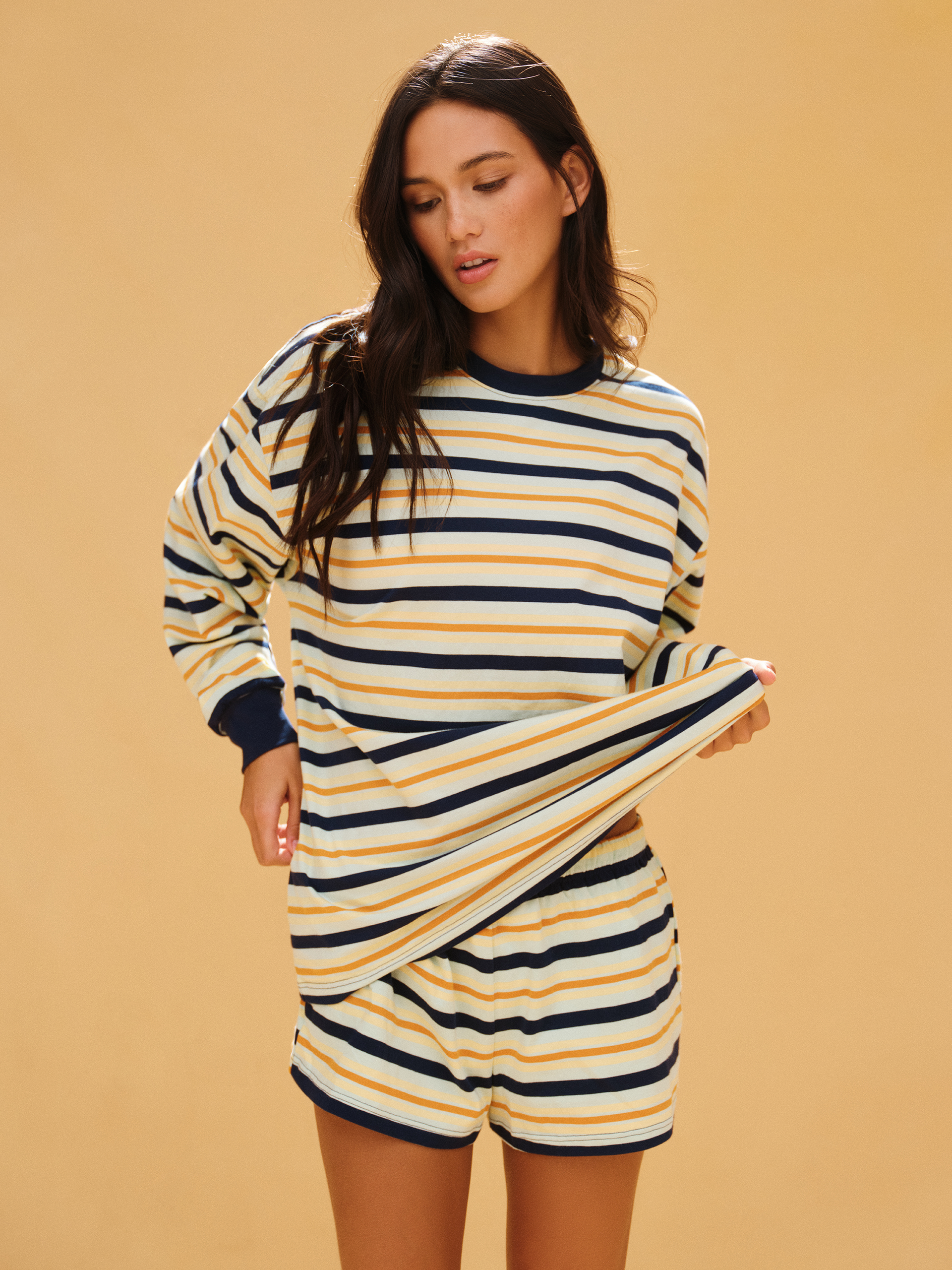 Woman wearing a striped dress with long sleeves on a beige background <model-info>Jelene wears a size XS and is 5’7”, 23” waist, 32AB bust.</model-info>