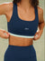 Navy blue sports bra with a light blue band and 'SET' logo on a neutral background