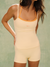 Woman wearing a beige tank top and shorts set with orange straps on a light green background <model-info>Jelene wears a size XS and is 5’7”, 23” waist, 32AB bust.</model-info>