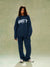 Person wearing a navy blue 'SET' sweatshirt and pants on a plain background