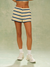 Person wearing striped shorts and white sneakers on a plain background <model-info>Jelene wears a size XS and is 5’7”, 23” waist, 32AB bust.</model-info>