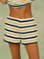 Striped shorts with yellow, navy, and white pattern on a neutral background