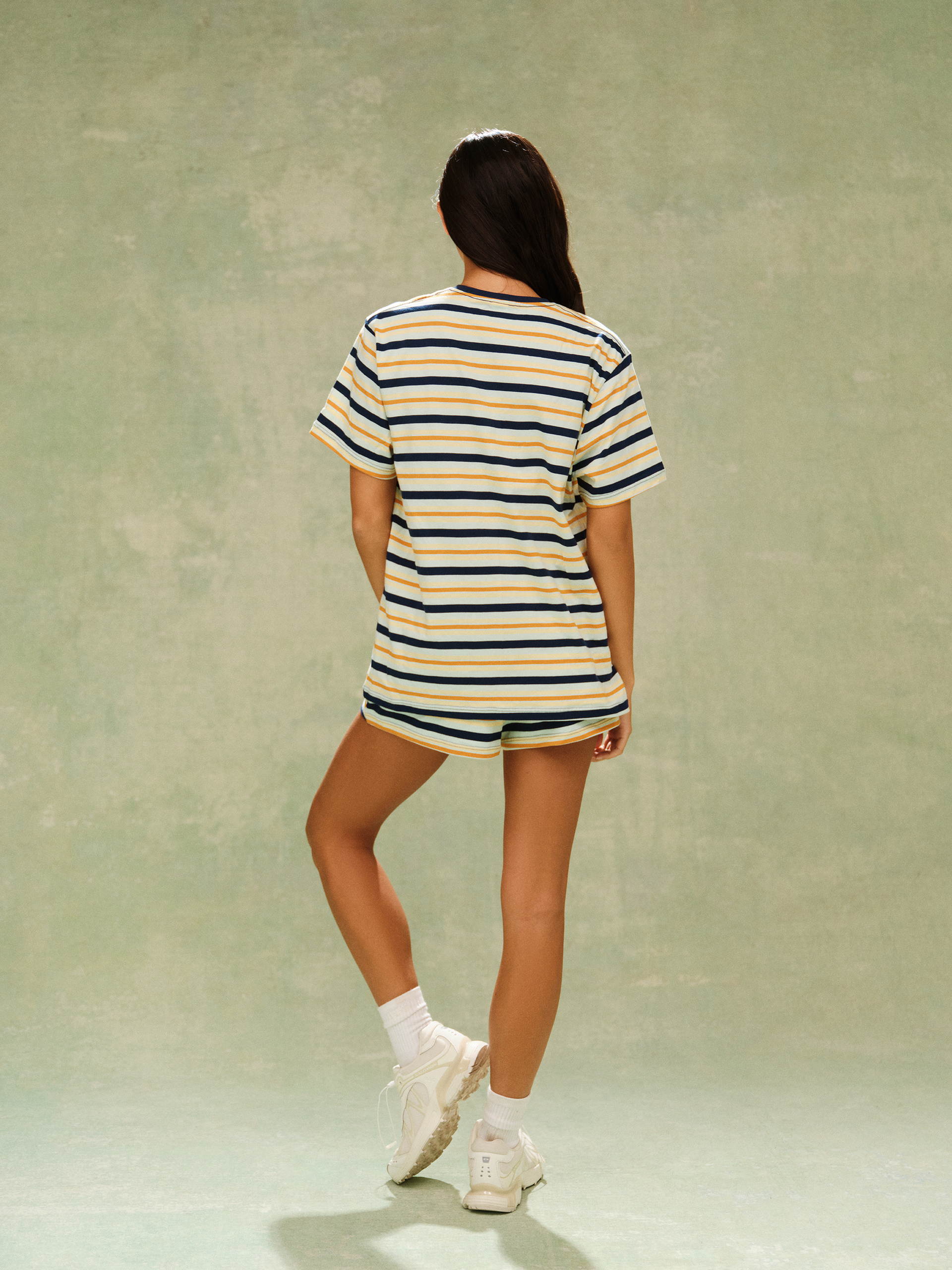 Person wearing a striped shirt and shorts set on a plain background