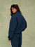 Woman wearing a navy blue outfit against a green background