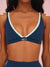 Navy sports bra with light green trim and 'SET' logo on a pink background