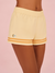 Yellow shorts with orange stripes on a pink background <model-info>Sydney wears a size XS and is 5’9, 24½” waist, 32B bust.</model-info>