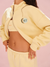 Person wearing a yellow tracksuit with 'SET' branding on a pink background