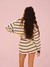 Person wearing a striped outfit on a pink background