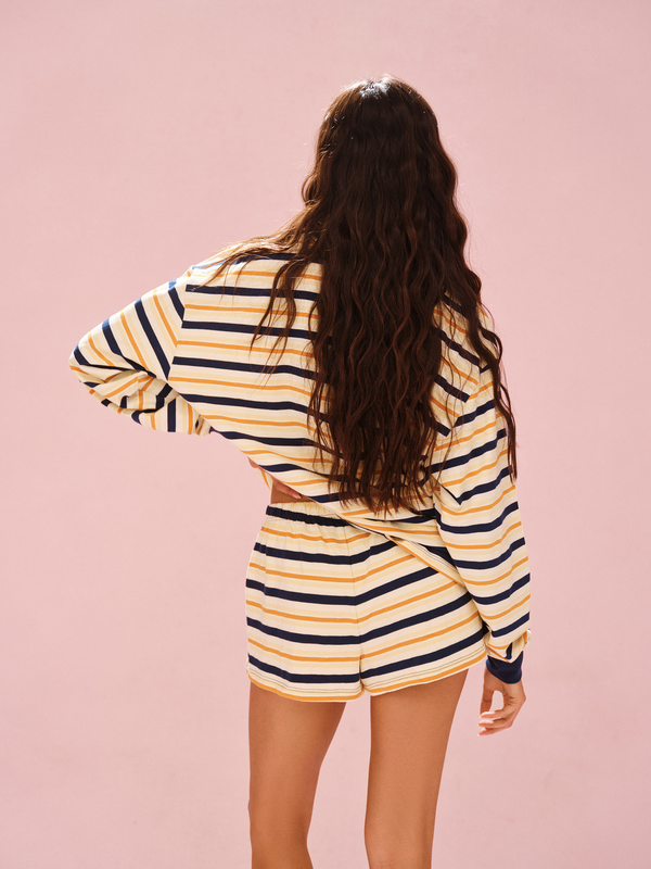 Person wearing a striped outfit on a pink background