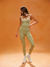 Woman wearing a green athletic outfit on an orange background