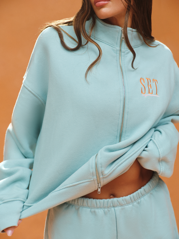 Light blue tracksuit with 'SET' branding on an orange background