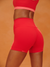 Red athletic shorts with a matching top on a brown background <model-info>Logan wears a size XS and is 5’9½”, 24” waist, 32B bust.</model-info>
