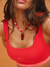 Person wearing a red tank top with 'SET' branding and a red beaded necklace.