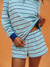 Person wearing a blue and white striped outfit against an orange background