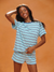 Woman wearing a blue and white striped pajama set against an orange background <model-info>Sydney wears a size XS and is 5’9, 24½” waist, 32B bust.</model-info>