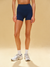 Person wearing navy blue athletic shorts on a beige background